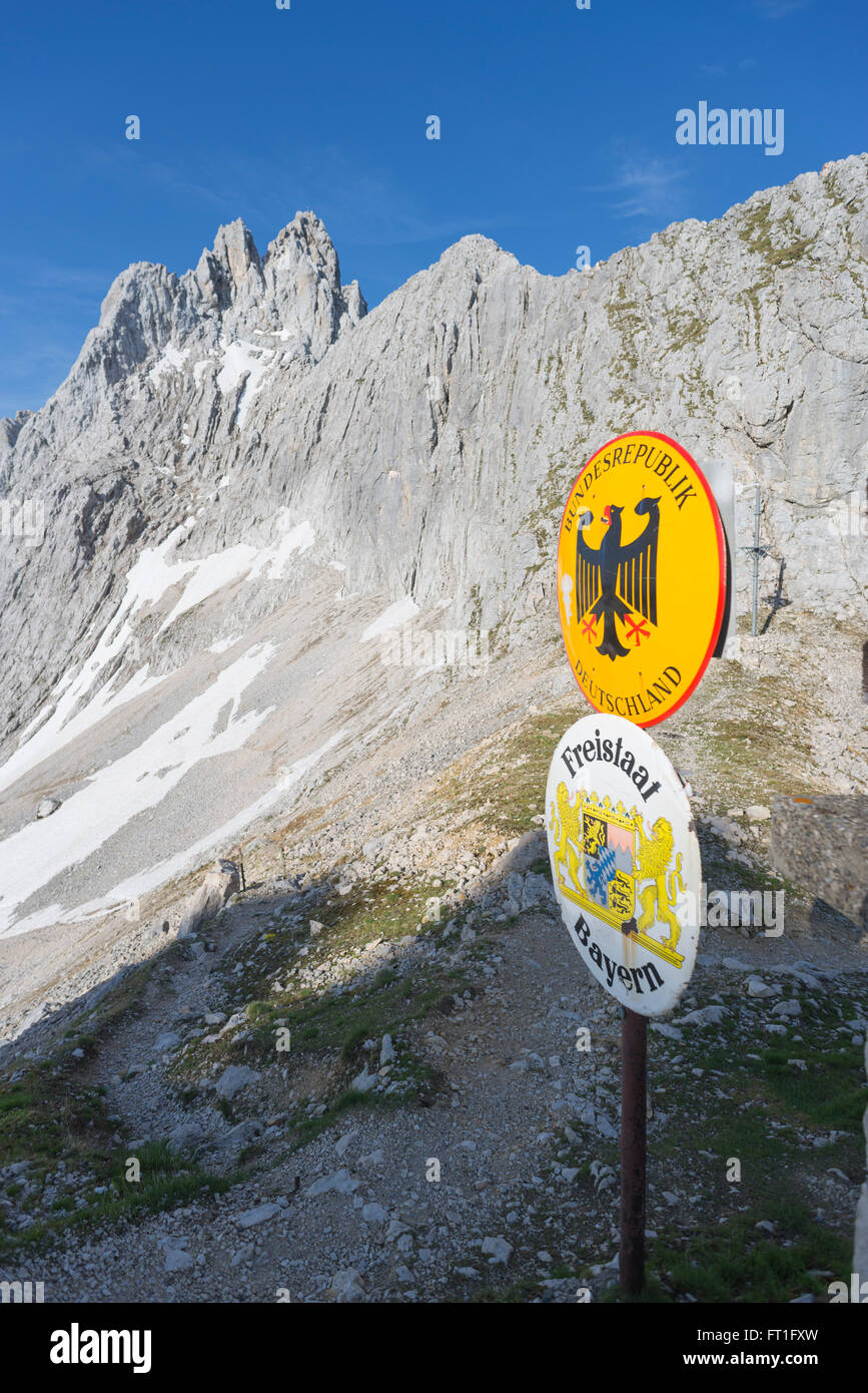 Border sign of Germany in front of peaks, cliffs and rocks on an alpine mountain pass to Austria, Wetterstein mountains,Bavaria Stock Photo