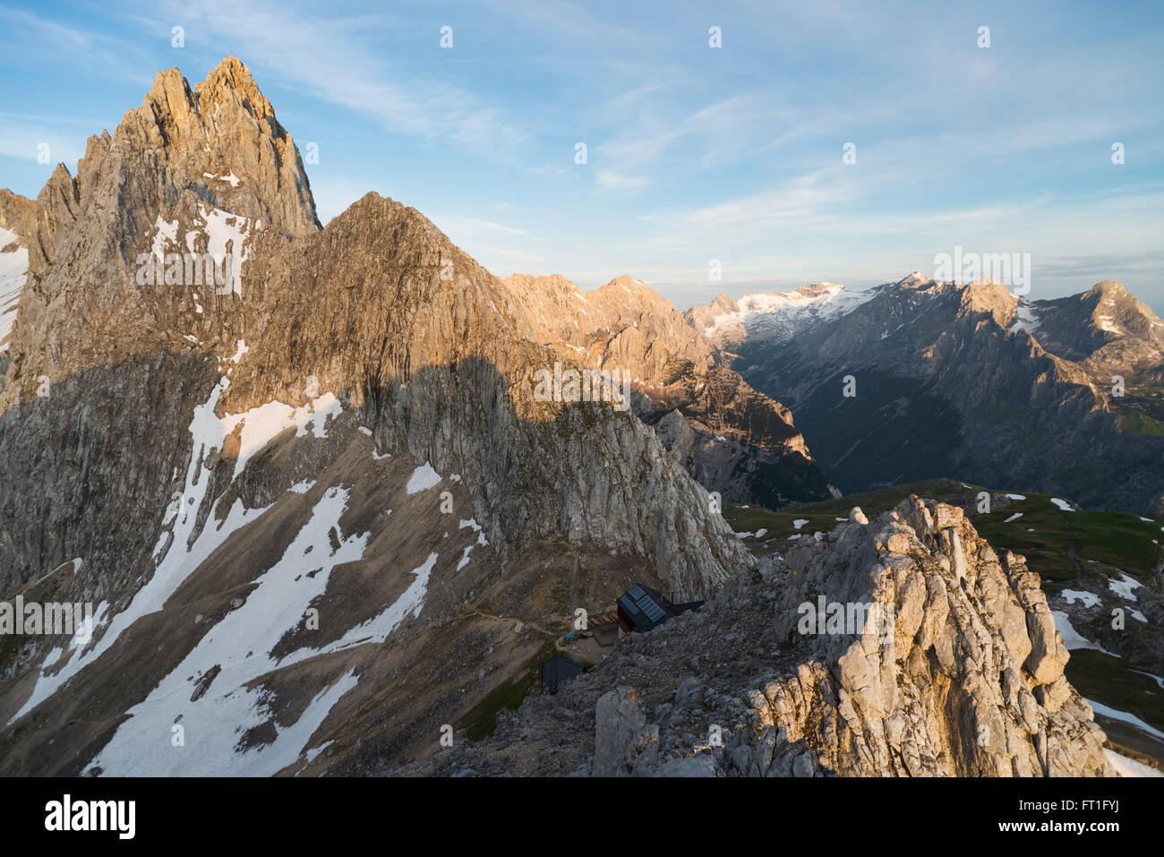 The Meilerhuette mountain hut at Mount Partenkirchner Dreitorspitze with Mount Alpspitze and Mount Zugspitze behind at sunrise Stock Photo