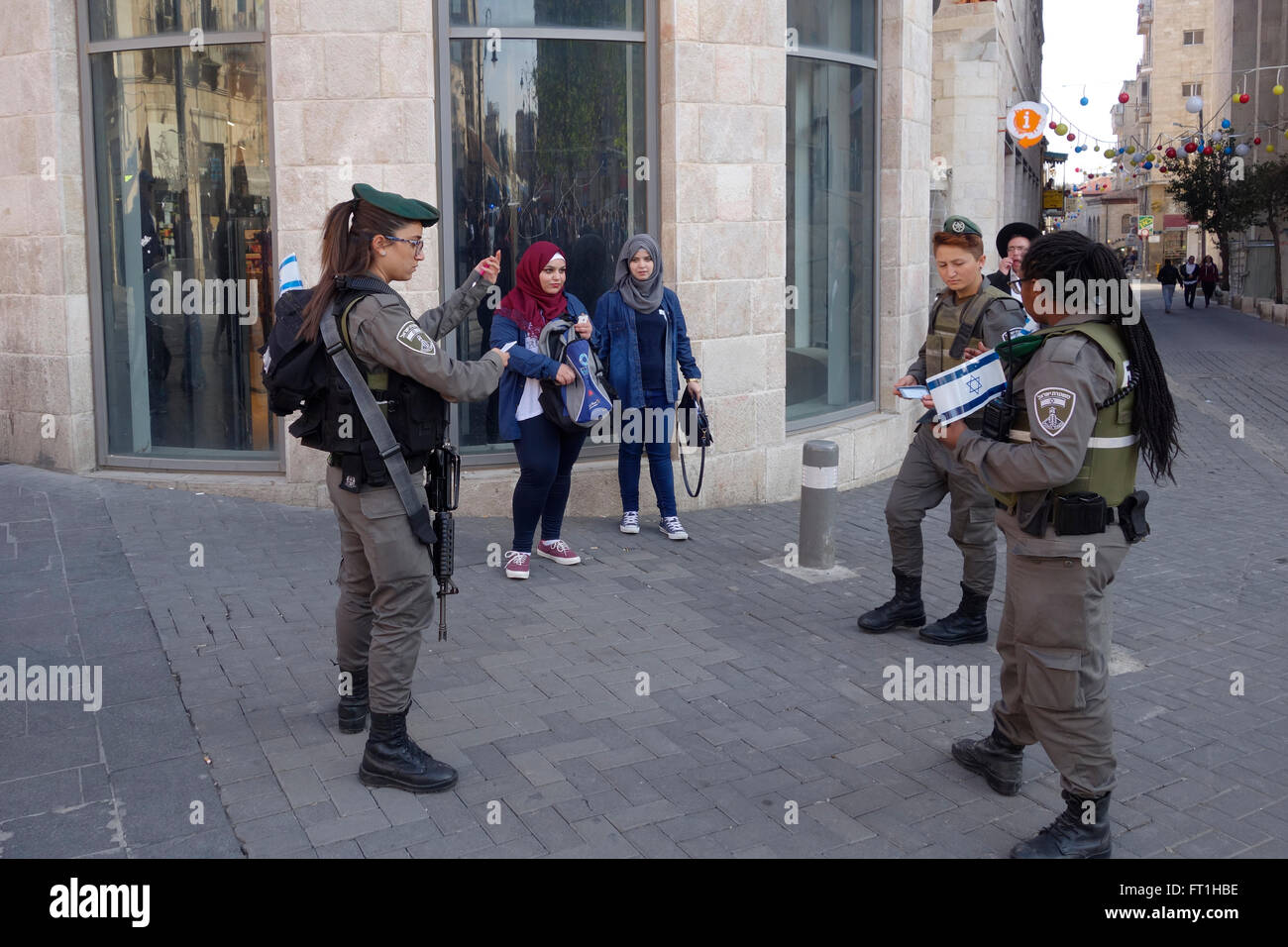 Israeli border policewoman cornering young Palestinian girls in the street for interrogation in West Jerusalem Israel Stock Photo
