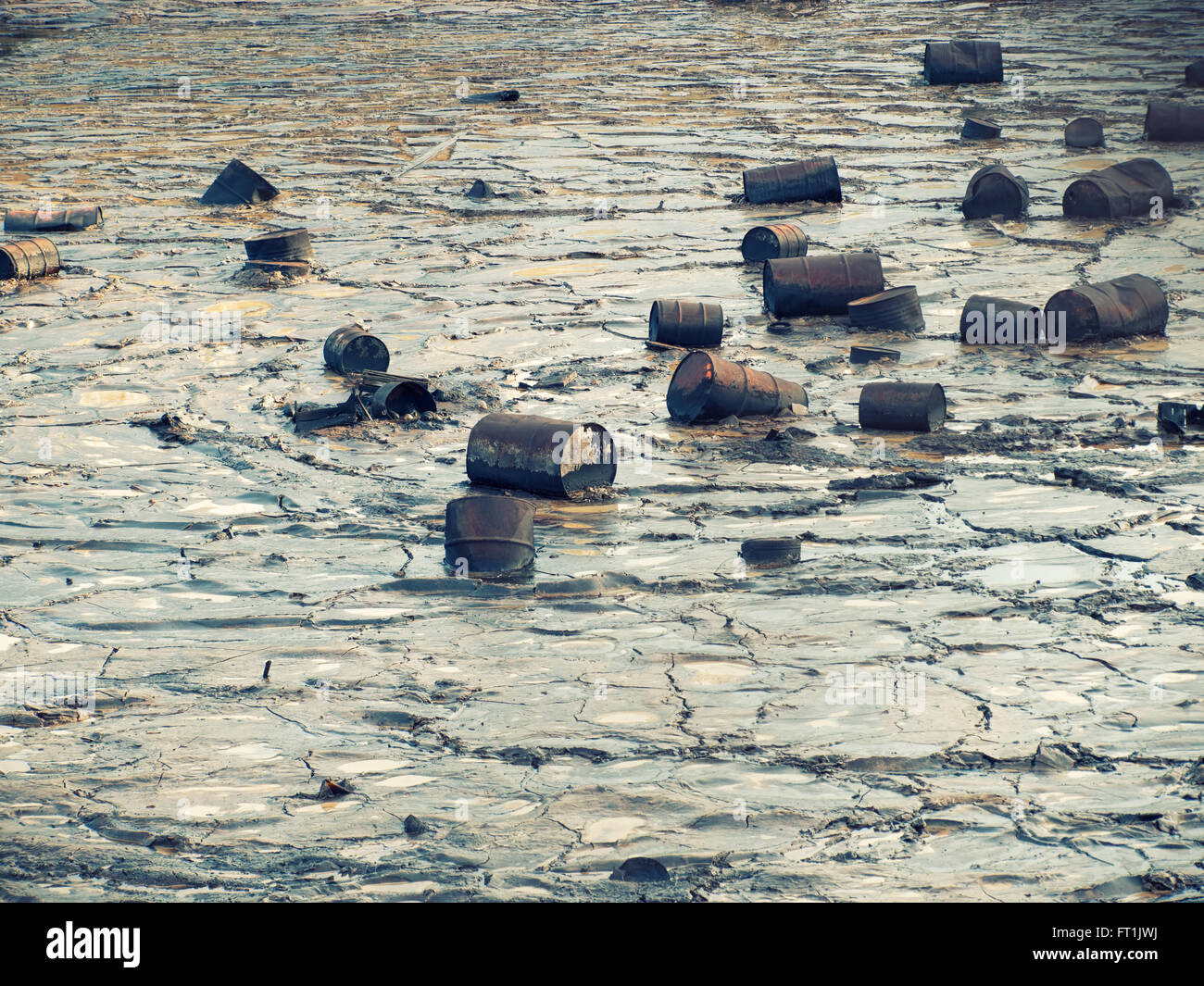 Tin barrels are floating on a oily water surface. Stock Photo