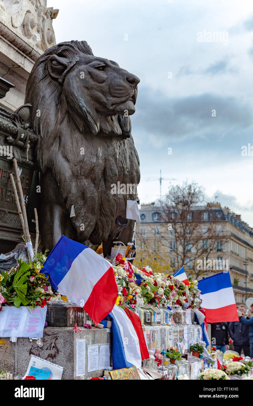 Flowers and flags paying tribute to terrorism victims in Paris France Stock Photo