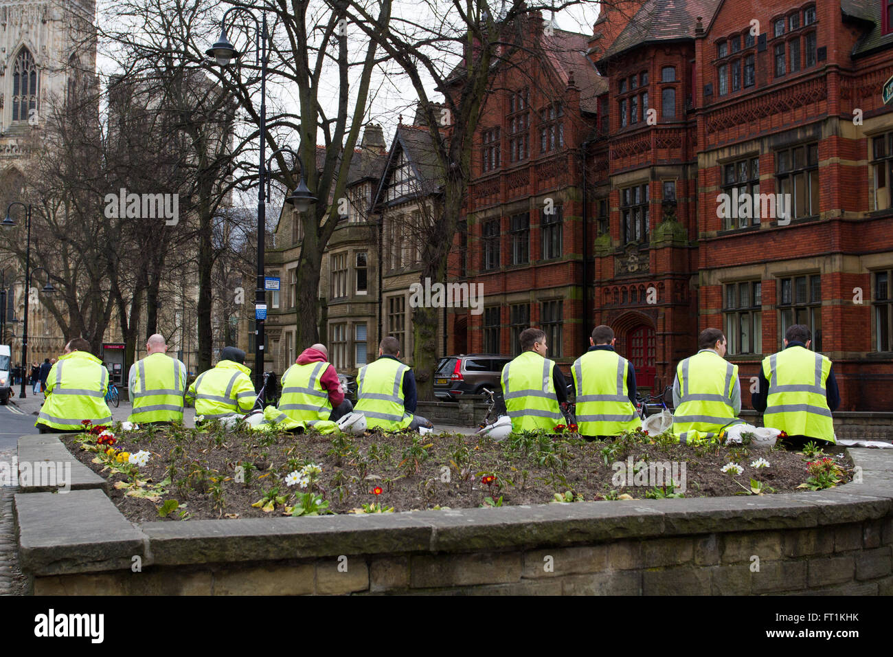 Construction workers in high visibility clothing sitting on the streets of York during a break in work. Stock Photo