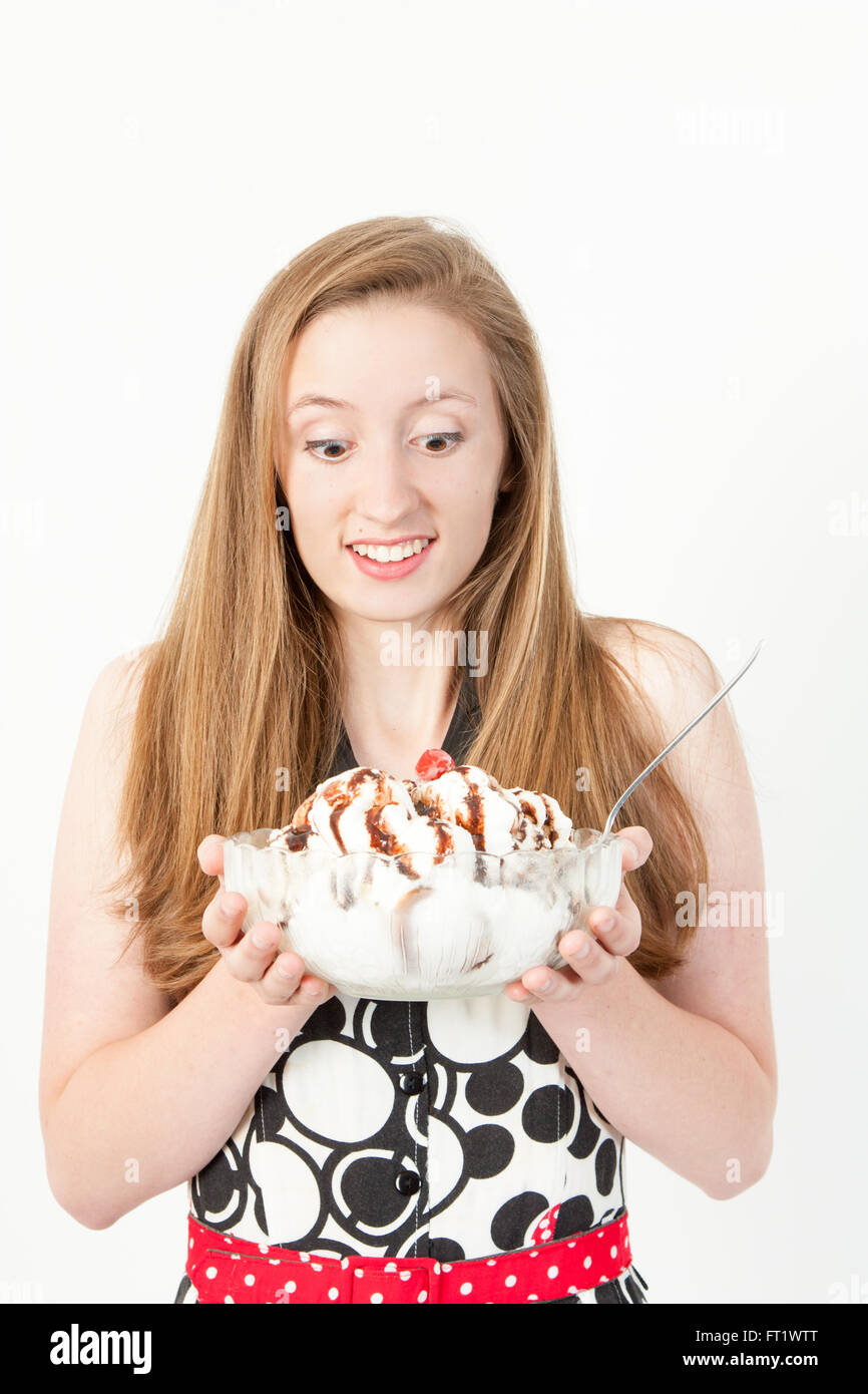 An excited young woman holds a huge ice cream sundae Stock Photo