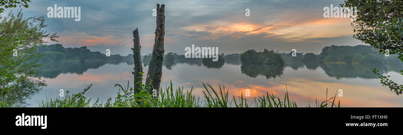 Panoramic scene of Attenborough nature reserve at sunset reflected in the water. Nottinghamshire, September Stock Photo