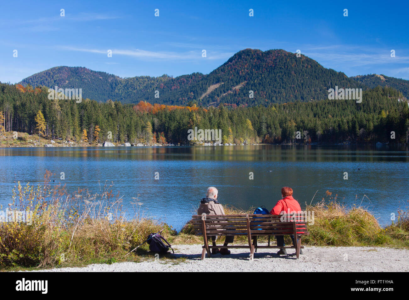 Elderly tourists on bench looking at Lake Hintersee in the Bavarian Alps, Berchtesgadener Land, Upper Bavaria, Germany Stock Photo