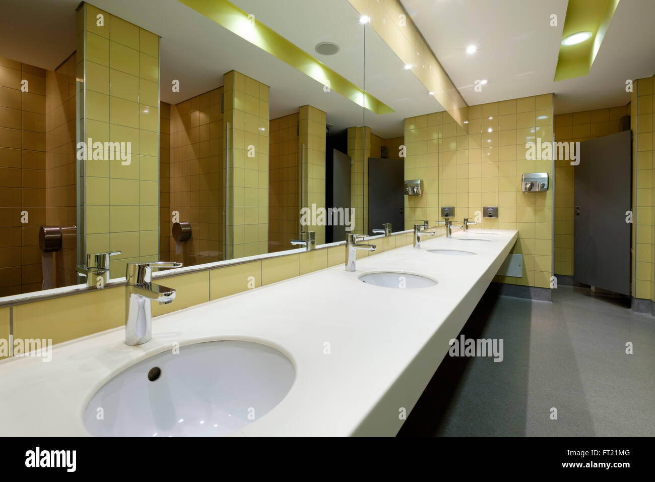 https://c8.alamy.com/comp/FT21MG/public-restroom-with-a-row-of-lavatories-in-front-of-a-large-mirror-FT21MG.jpg