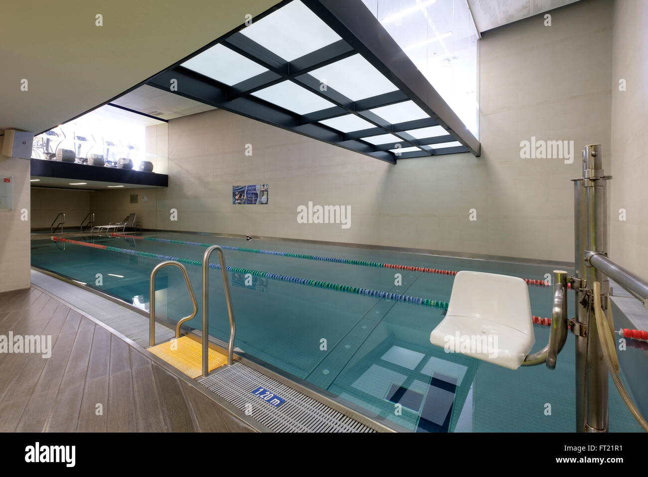 Indoor swimming pool entry ladder and disabled person chair Stock Photo