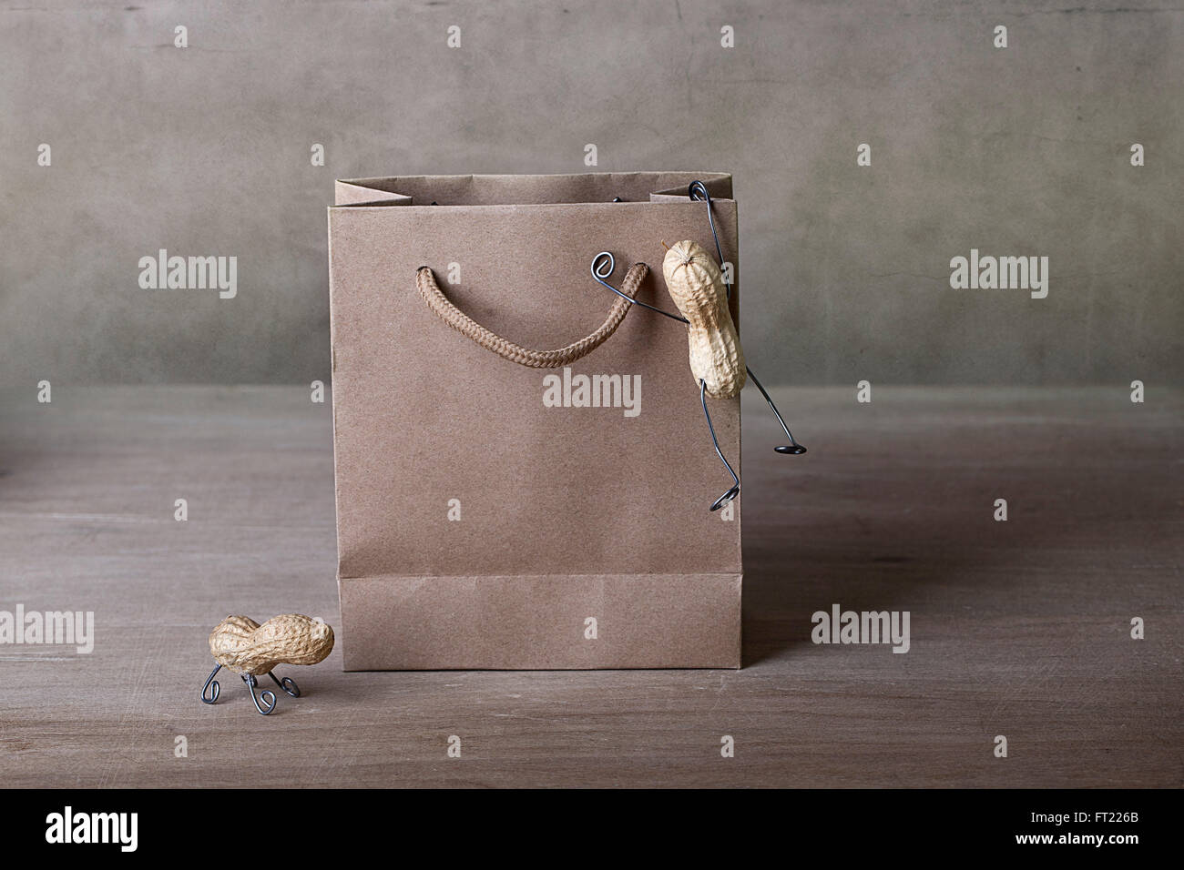 Miniature with Peanut People Climbing into Shopping bag Stock Photo