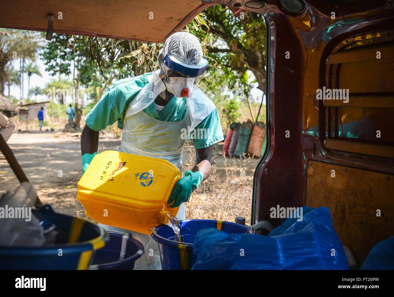 A medical team member prepares chlorinated water for decontamination of a victim of the Ebola virus February 10, 2015 in Port Loko District, Sierra Leone. Stock Photo