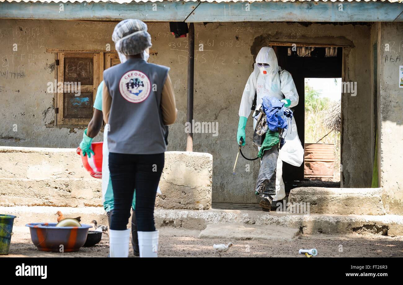 A medical team member removes personal belongings from the home of an Ebola virus victim during decontamination April 28, 2015 in Port Loko District, Sierra Leone. Stock Photo