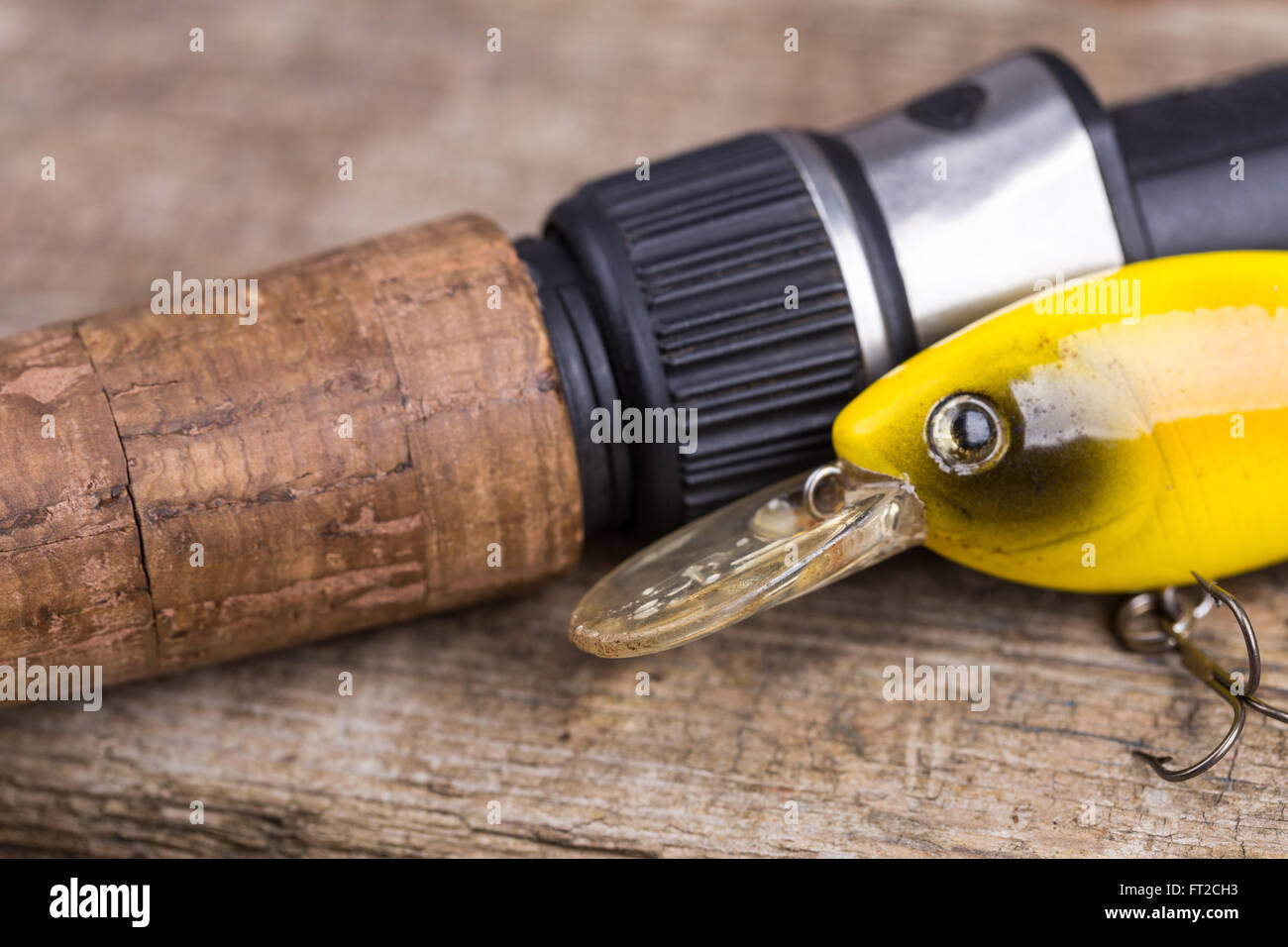 closeup cork handle of fishing rod with lure on wooden board background.  Concept design for freshwater outdoor active business c Stock Photo - Alamy