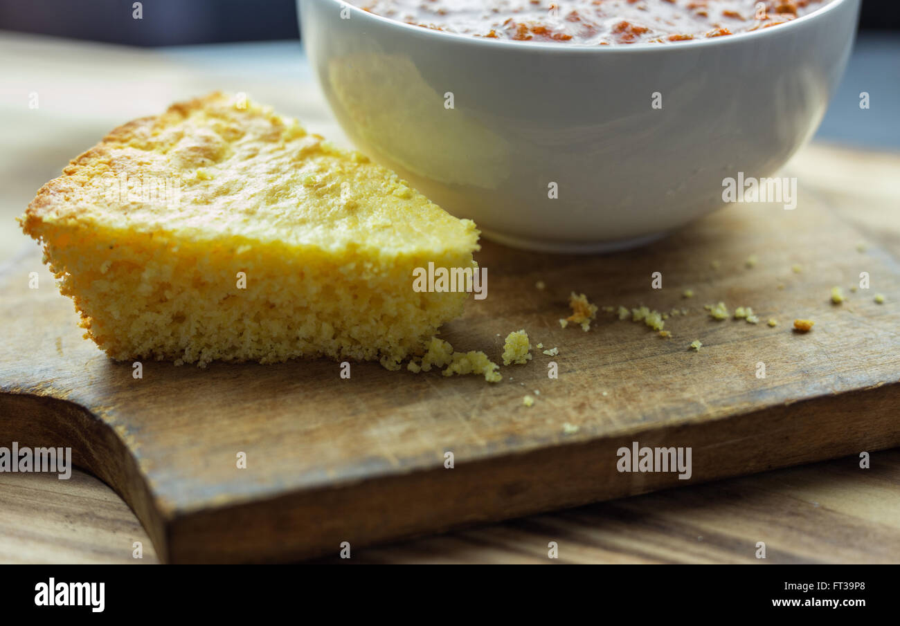 A slice of cornbread with a bowl of chili Stock Photo Alamy