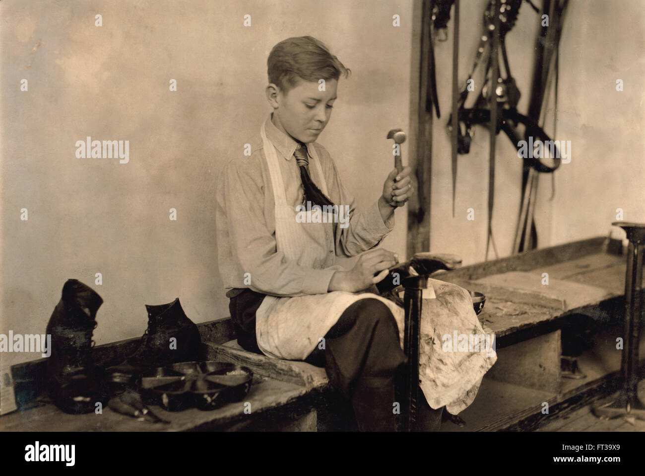 Young Boy Learning to Make Shoes at Training School for Deaf Mutes, Sulphur, Oklahoma, USA, circa 1917 Stock Photo