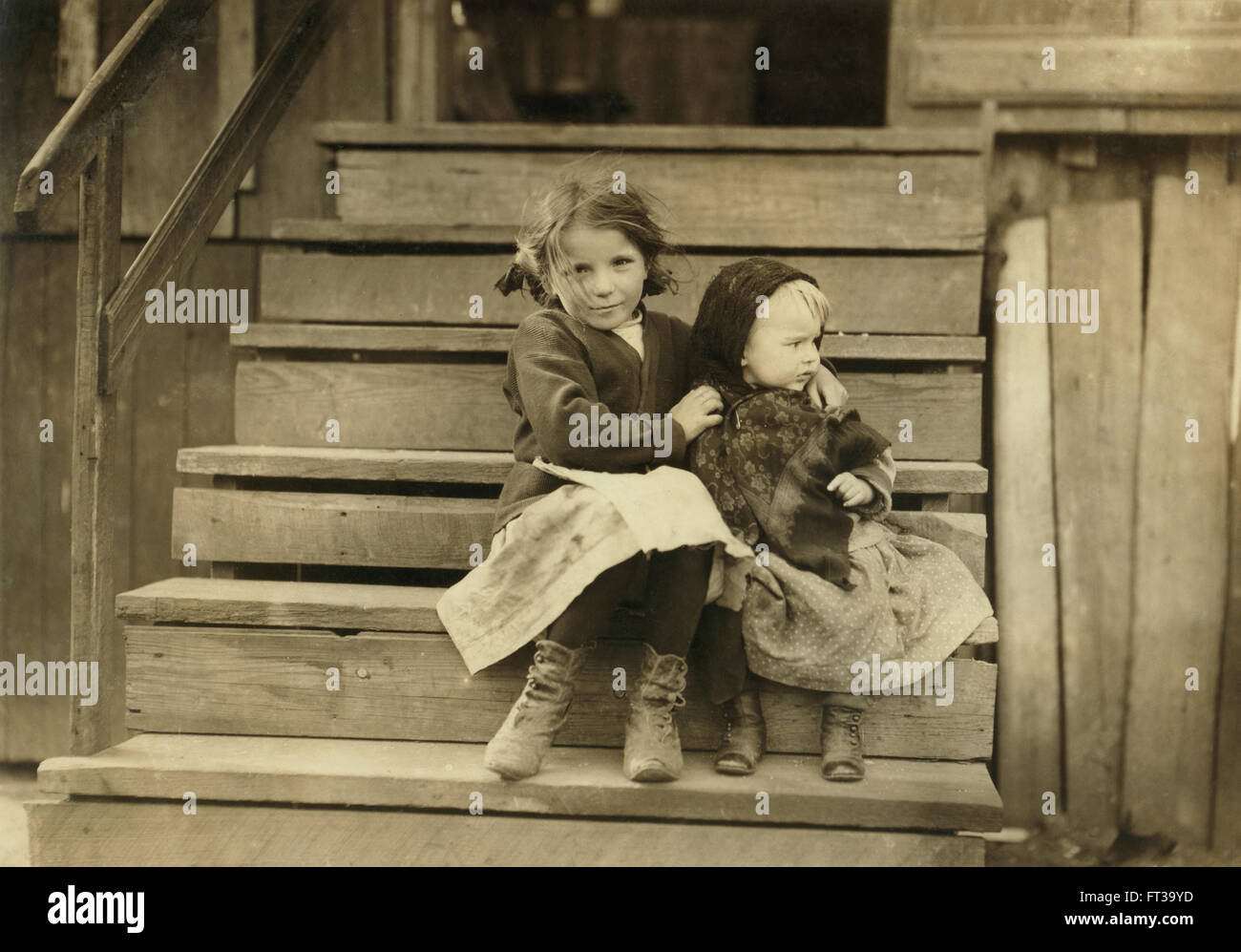 Portrait Young Girl Taking Care Baby Sister While Rest Family is Working Local Cannery Bayou La Batre Alabama USA circa 1911 Stock Photo
