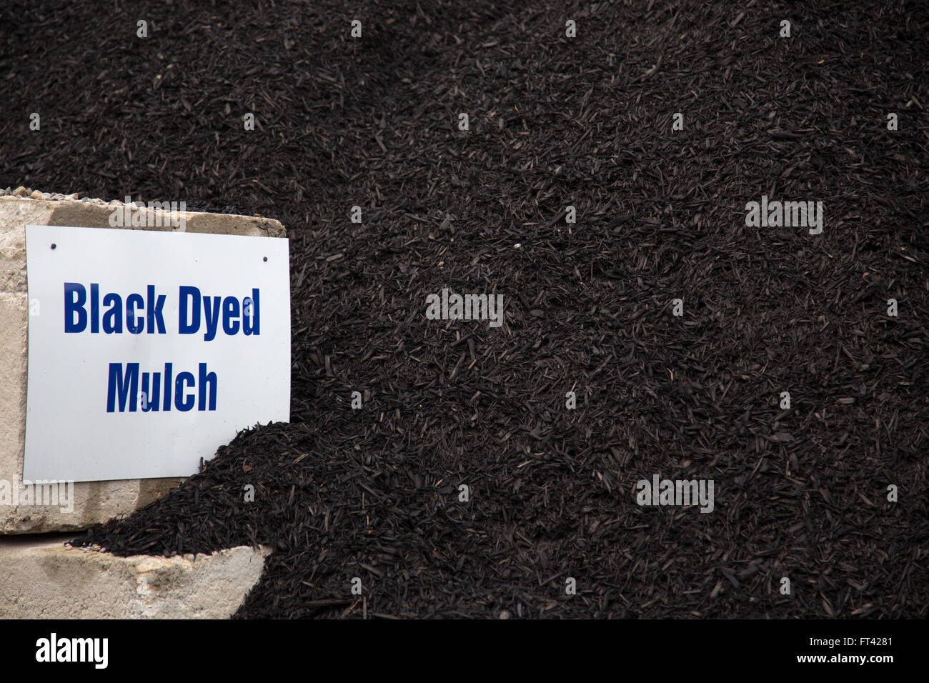 Black dyed mulch in a large pile for landscaping at garden centre Stock Photo