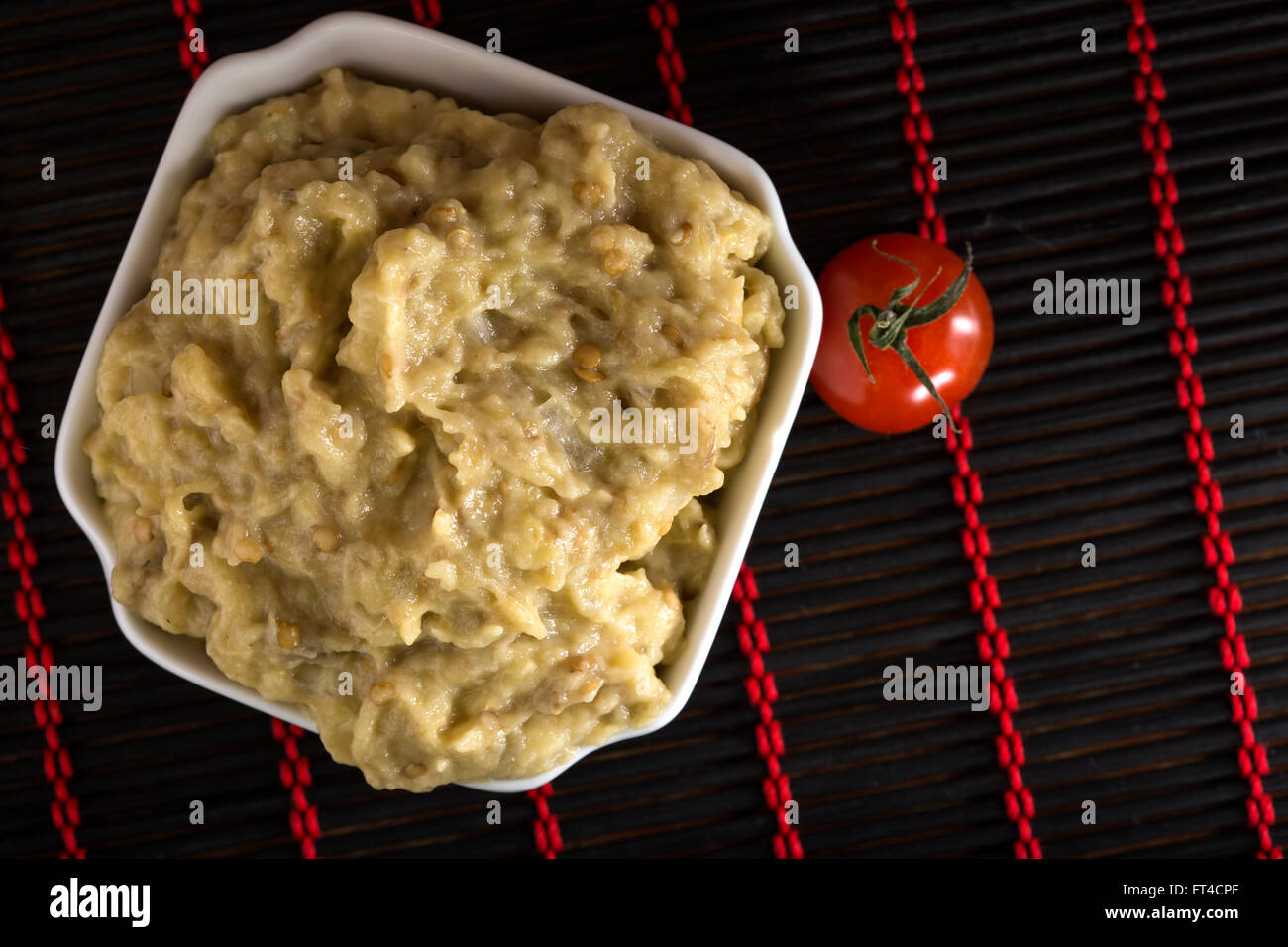Eggplant salad with mayonnaise and one cherry tomato Stock Photo