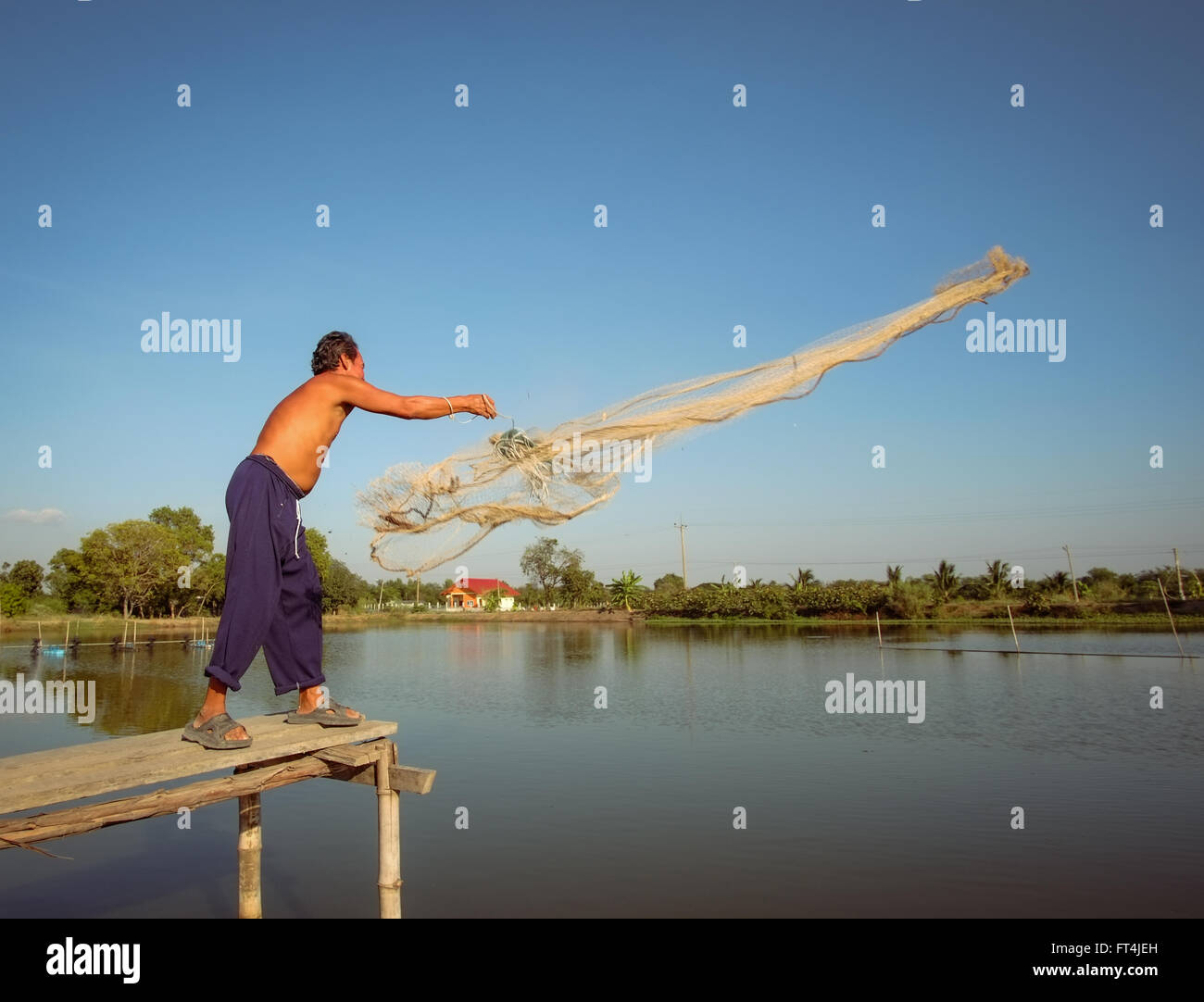 Local Thai farmer casting out net. Stock Photo