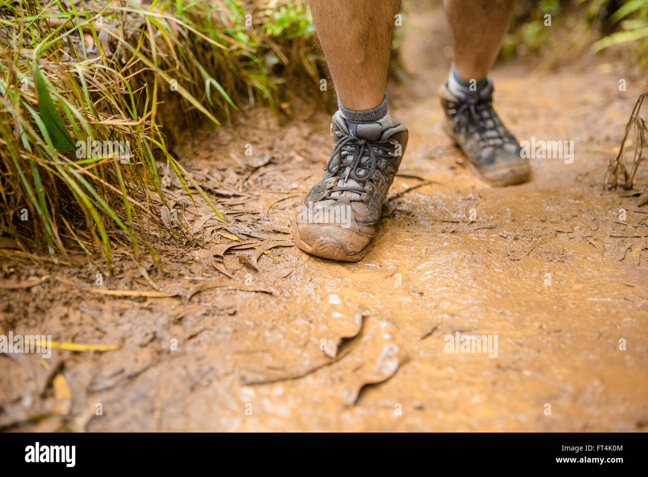 Male muddy hiking boot on mud Stock Photo