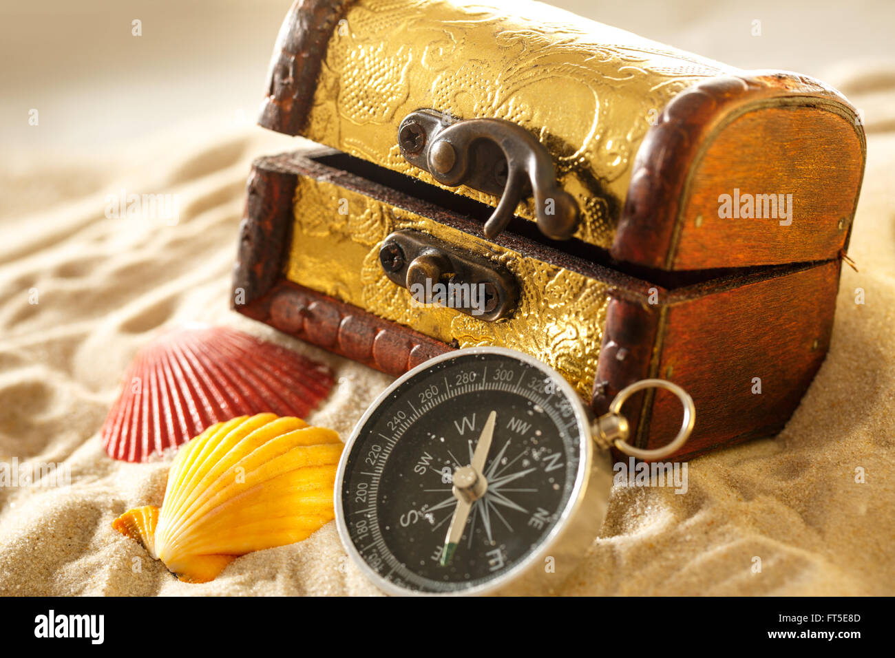 Treasure chest with seashells and compass on sand Stock Photo Alamy