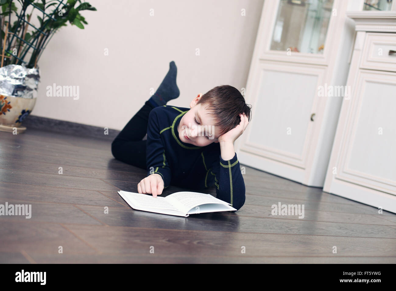 Child reeding book lying on the floor Stock Photo Alamy