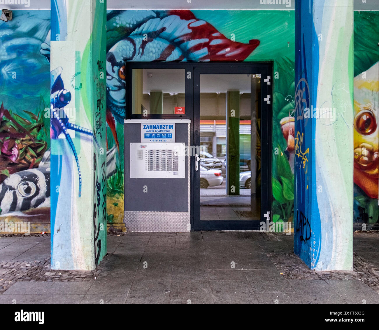 Berlin Kreuzberg Dental practice entrance covered in street art - old murals of previous tenant, pet shop, Aquariem Meyer Stock Photo