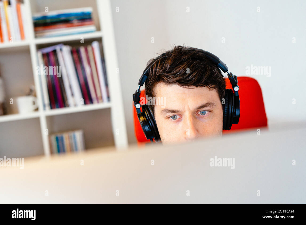 Businessman wearing headphones while using computer in office Stock