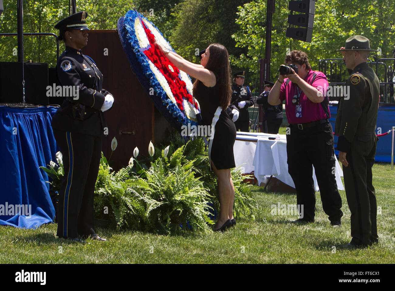 051515: Washington, DC - During Police Week the National Peace Officer's Memorial Service was held at the Capitol in honor of fallen agents and officers across the nation.  The sister of fallen agent Alexander Giannini pins a memorial flower to the wreath during the Roll Call of Heroes of 2014. Photographer: Donna Burton Stock Photo