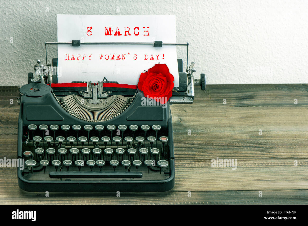 Happy Womens Day! Vintage typewriter with white paper page and red rose flower Stock Photo