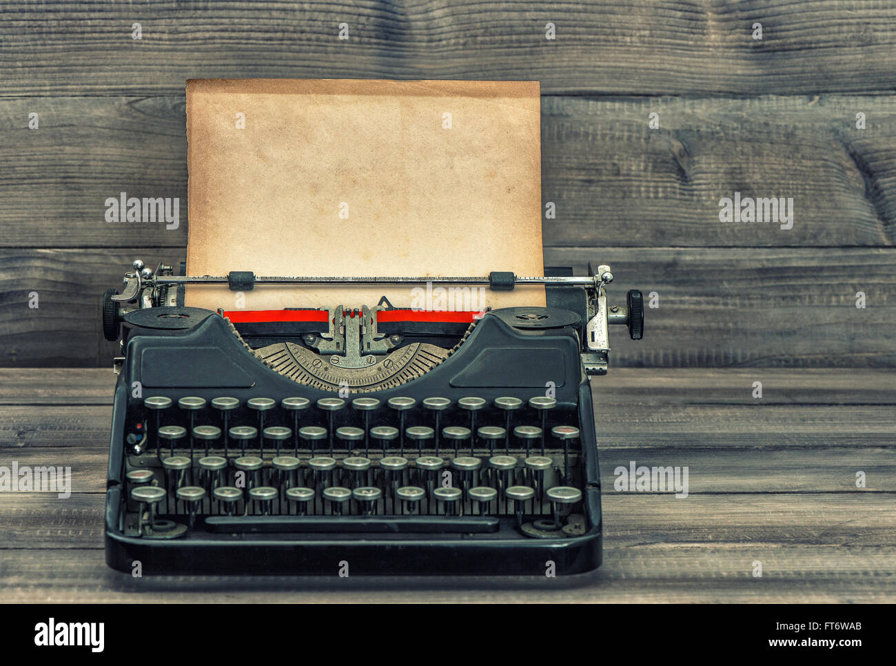 Antique typewriter with grungy textured paper page. Vintage style toned picture Stock Photo