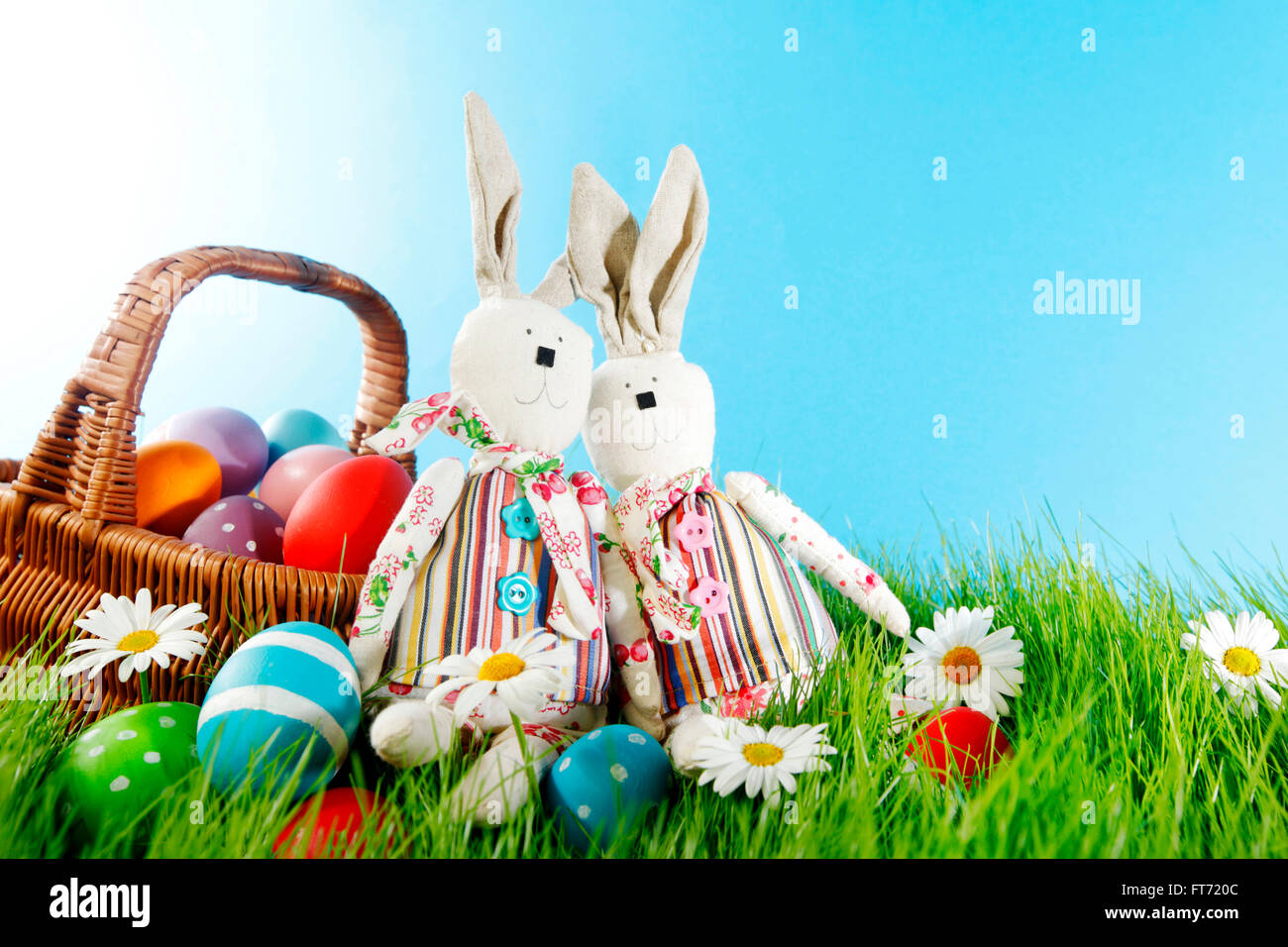 Easter basket with eggs and rabbits on green meadow with flowers Stock ...