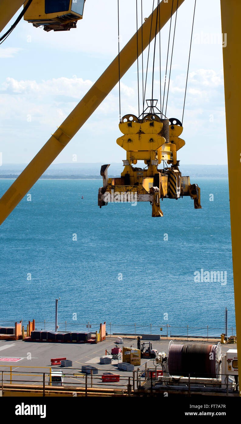Crane lifts heavy shipping container transports to terminal Stock Photo