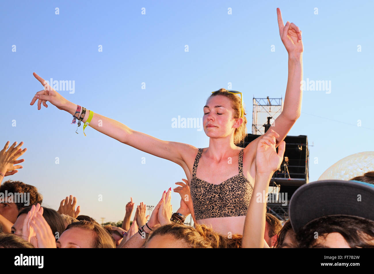 BENICASSIM, SPAIN - JULY 19: Young woman from the crowd with her arms raised in a concert at FIB. Stock Photo