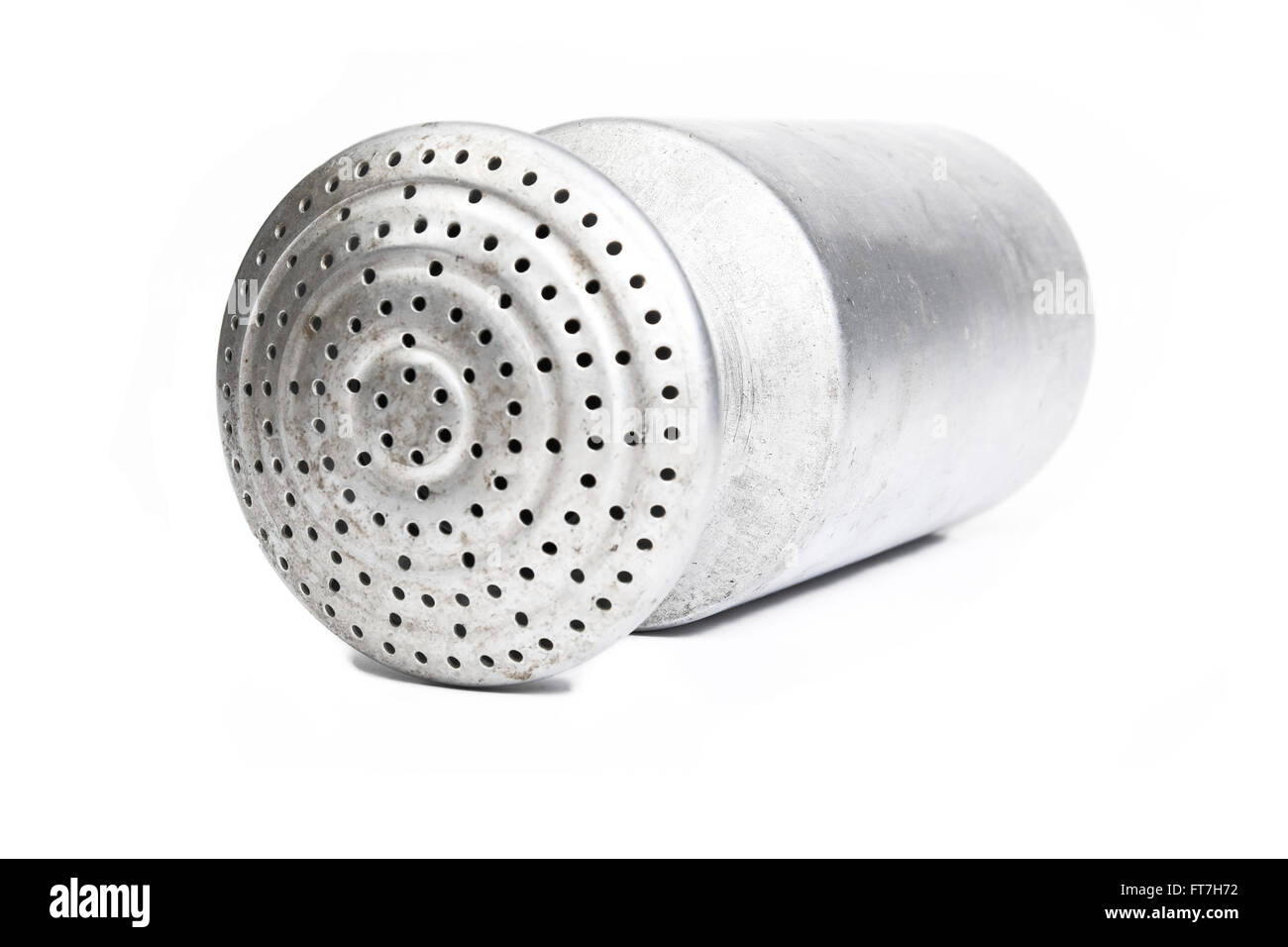 Aluminum salt shaker, with the top full of holes on, lying in front of a white background Stock Photo