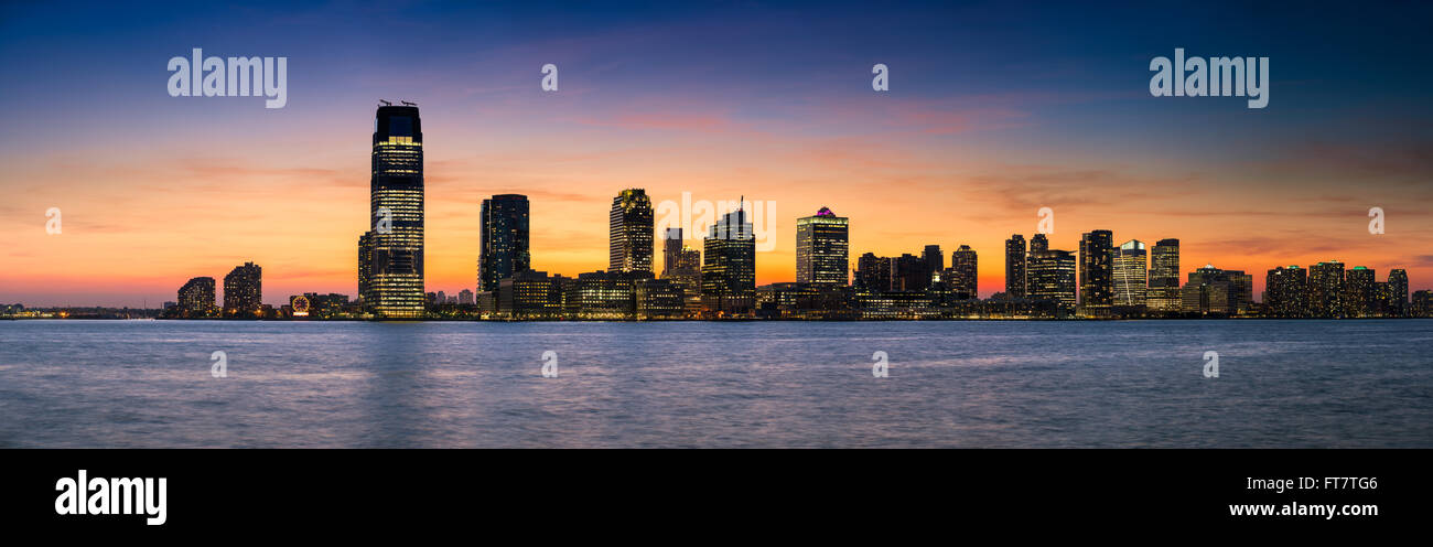 Panoramic skyline view of sunset over the Hudson River and Downtown Jersey City skyscrapers (including Goldman Sachs Tower) Stock Photo