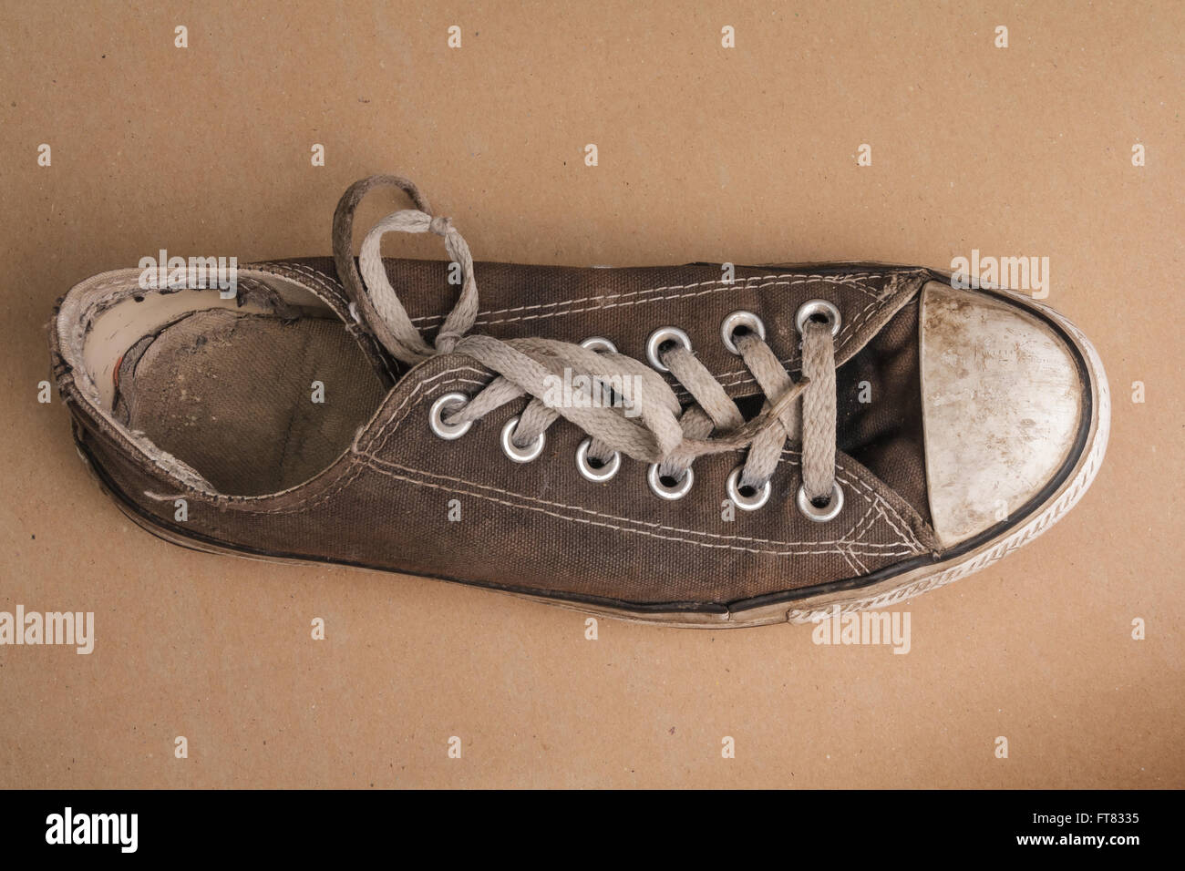 Very dirty tennis shoe standing on brown surface Stock Photo Alamy