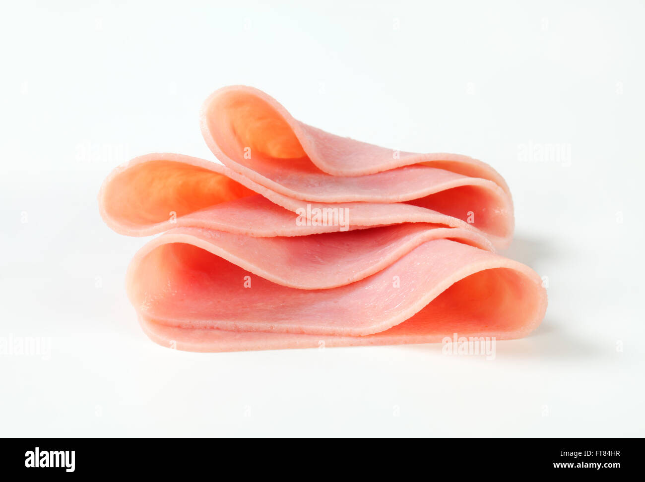 Thin slices of ham on white background Stock Photo