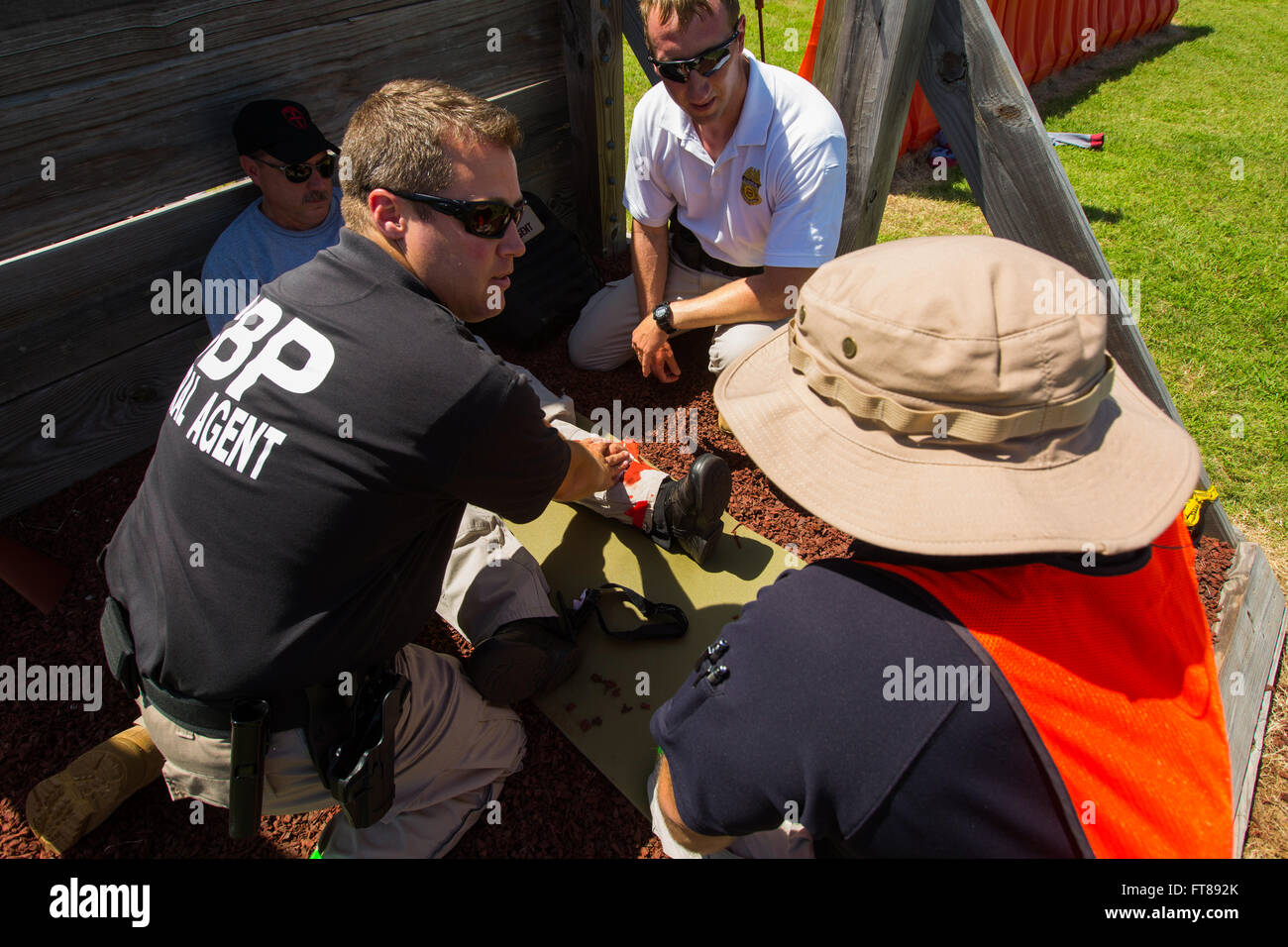 CBP Office of Air and Marine Pilots undergo training with crash scenarios simulating serious injuries at the National Air Training Center location in Oklahoma City, Oklahoma. Using role players this student simulates applying pressure to a leg wound. Photos by James Tourtellotte Stock Photo