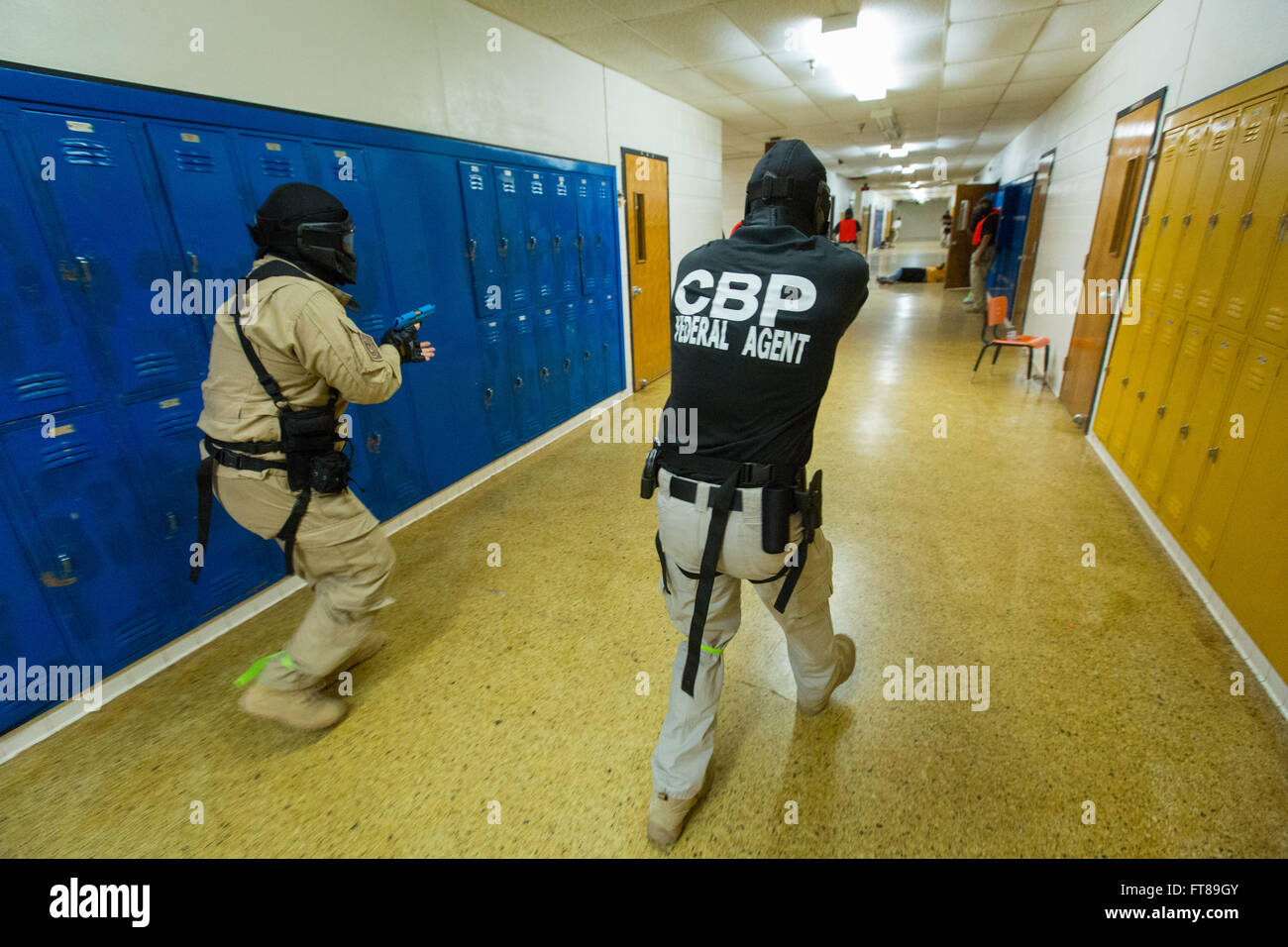 CBP Office of Air and Marine Pilots participate in an Active Shooter Scenario at an NATC facility to learn how to safely interact with other law enforcement communities in a dynamic enviroment to protect citizens and neutralize threats in a school based situation. Students and instructors move thru an abandoned school training for the Active Shooter Scenario making sure to wear important safety equipment. Photo by James Tourtellotte Stock Photo