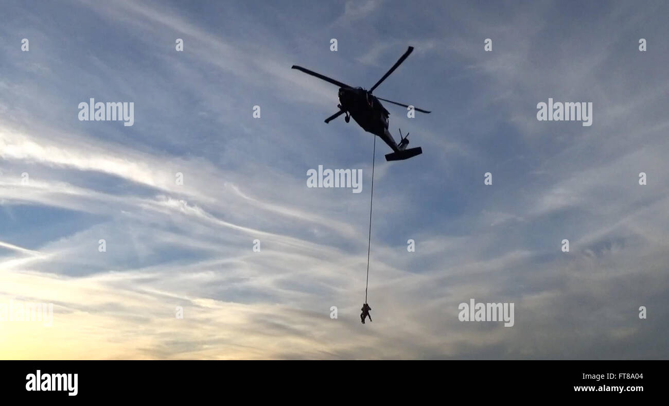 A Blackhawk helicopter from Air and Marine Operations flies over Davis-Monthan Air Force Base in Tucson, Arizona, carrying Tucson Police SWAT team members during FRIES (Fast Rope Insertion Extraction System) training. This training is part of joint operations with law enforcement agencies. Stock Photo