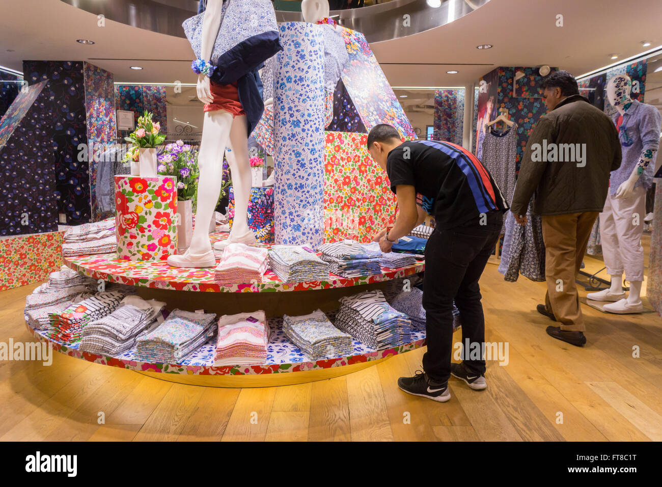 An employee arranges Liberty London merchandise in the Uniqlo store on  Fifth Avenue in New York on Thursday, March 24, 2016 during the  collaboration between Uniqlo and Liberty London, a company known