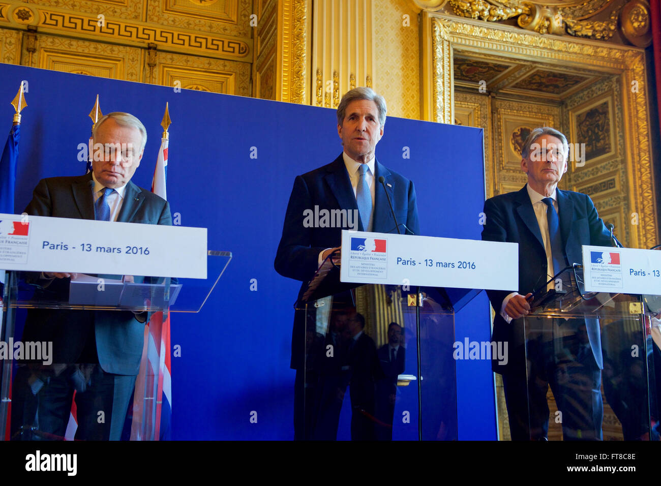U.S. Secretary of State John Kerry stands between French Foreign Minister Jean-Marc Ayrault and British Foreign Secretary Philip Hammond on March 13, 2015, at the Quai d'Orsay in Paris, France, addresses reporters after he and his counterparts held an E4+1 meeting - including representatives of France, Germany, Italy, the United Kingdom, and European Union - focused on Syria, Libya, Yemen, Ukraine, and other foreign policy matters. [State Department Photo/Public Domain] Stock Photo