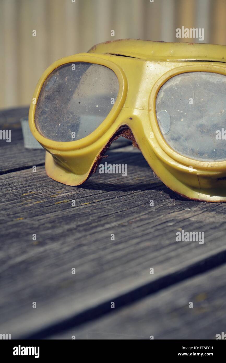 Yellow vintage safety glasses on a wooden table Stock Photo