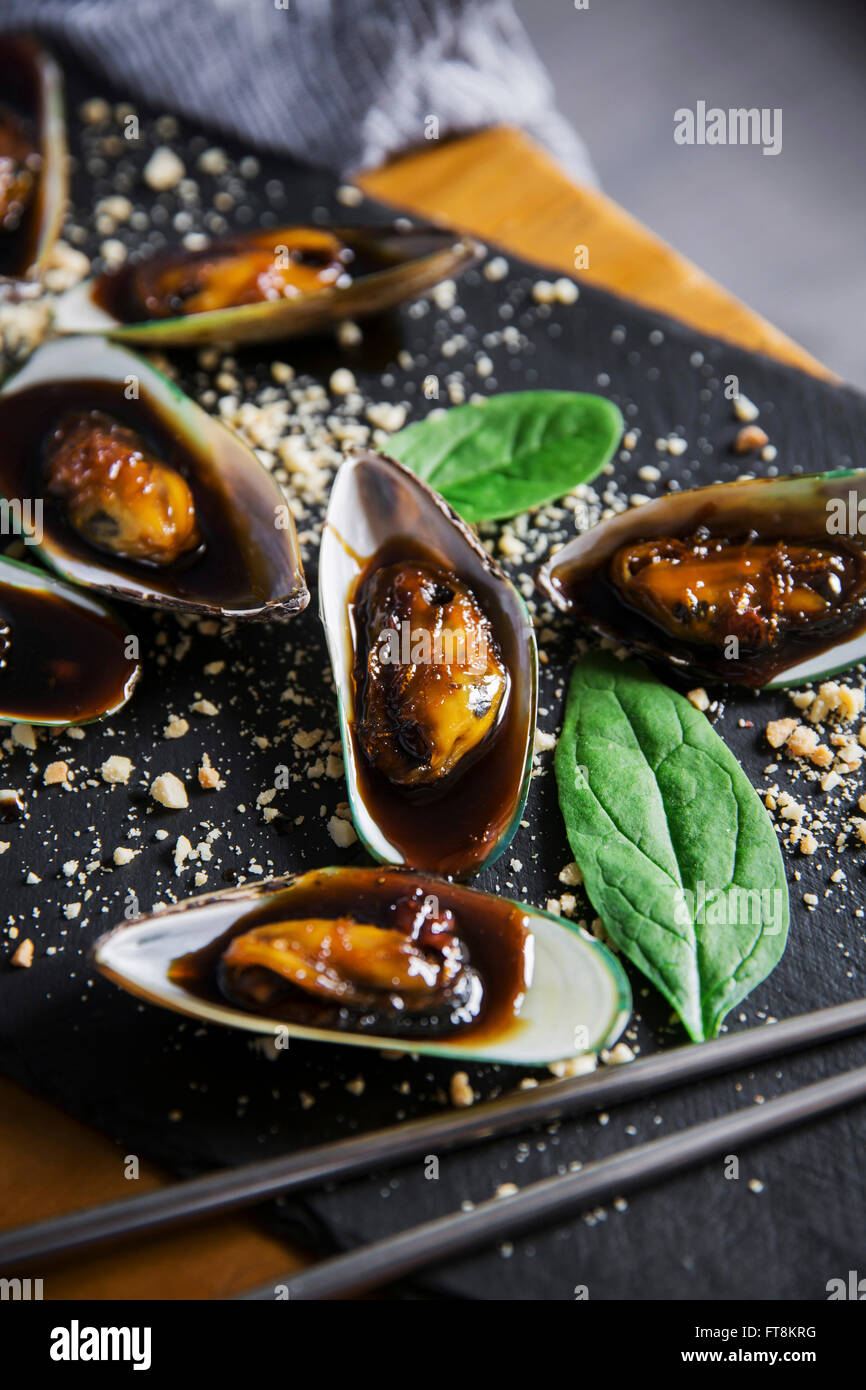Asian dish mussels in sticky sweet sauce, with peanuts and spinach Stock Photo Alamy