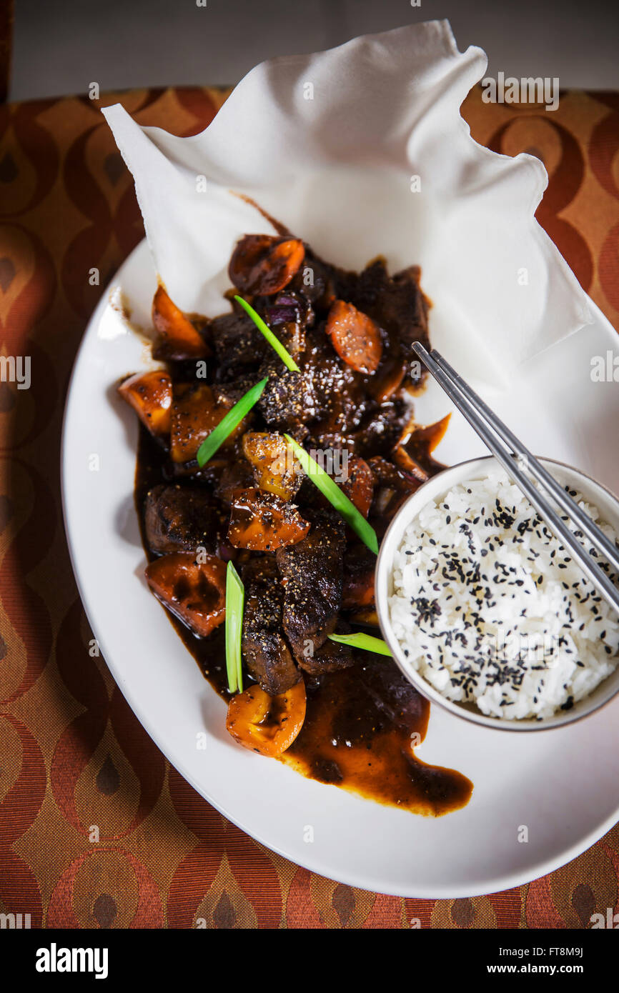 Asian dish beef in black pepper sauce, with rice, shot on vintage