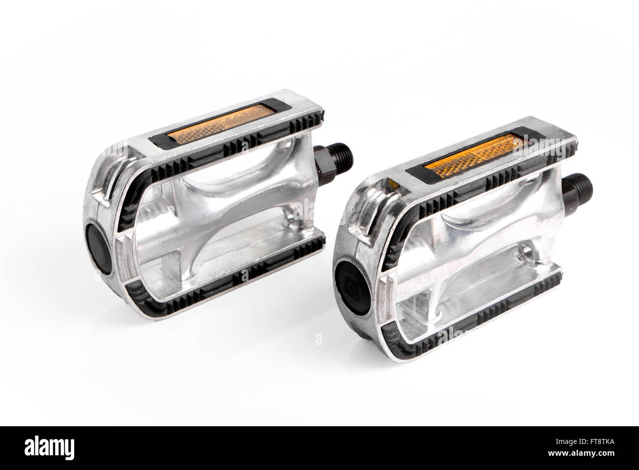 Two bicycle pedals of aluminum standing on white surface Stock Photo