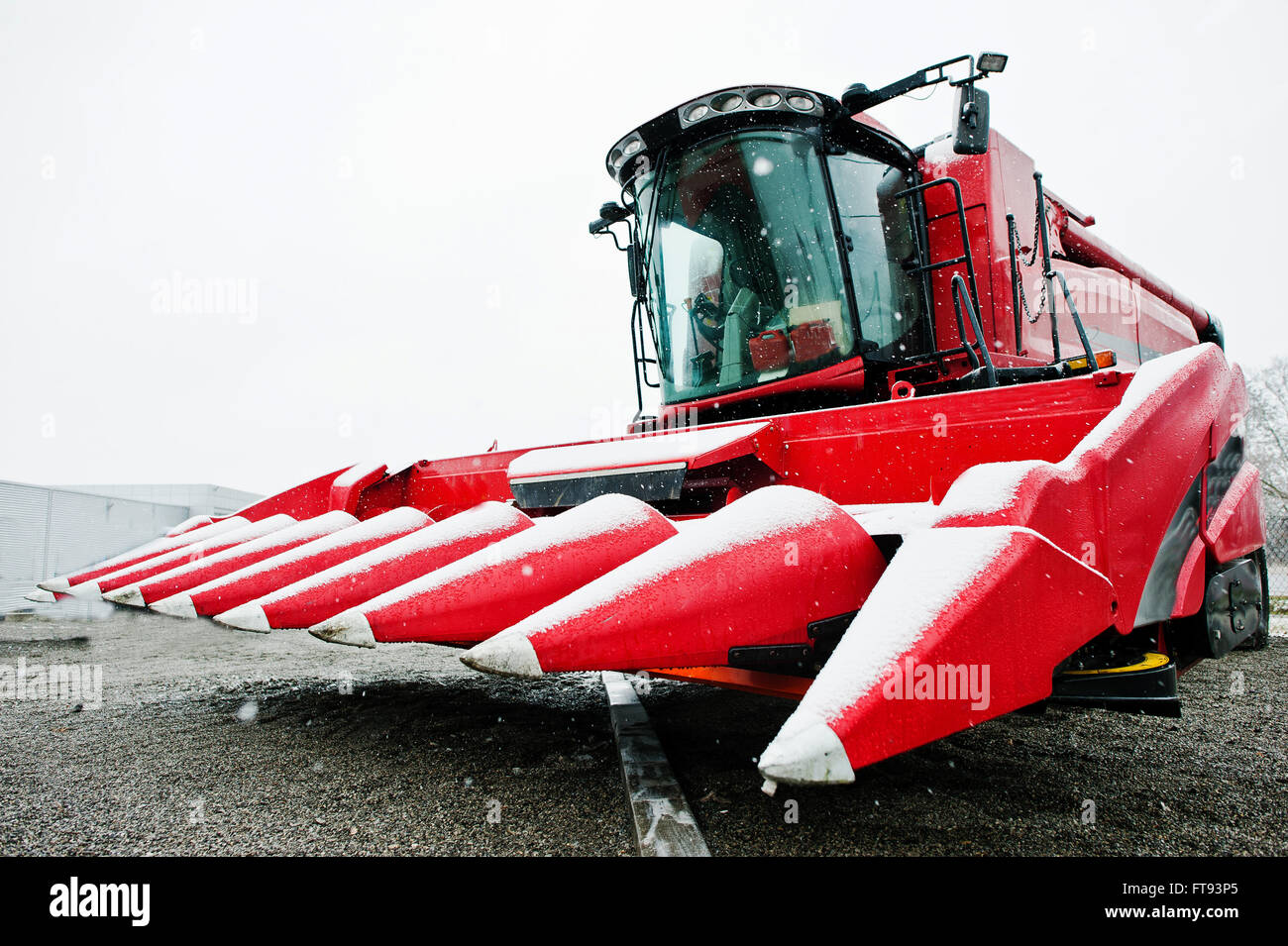 New red combine harvester at snowy weather Stock Photo