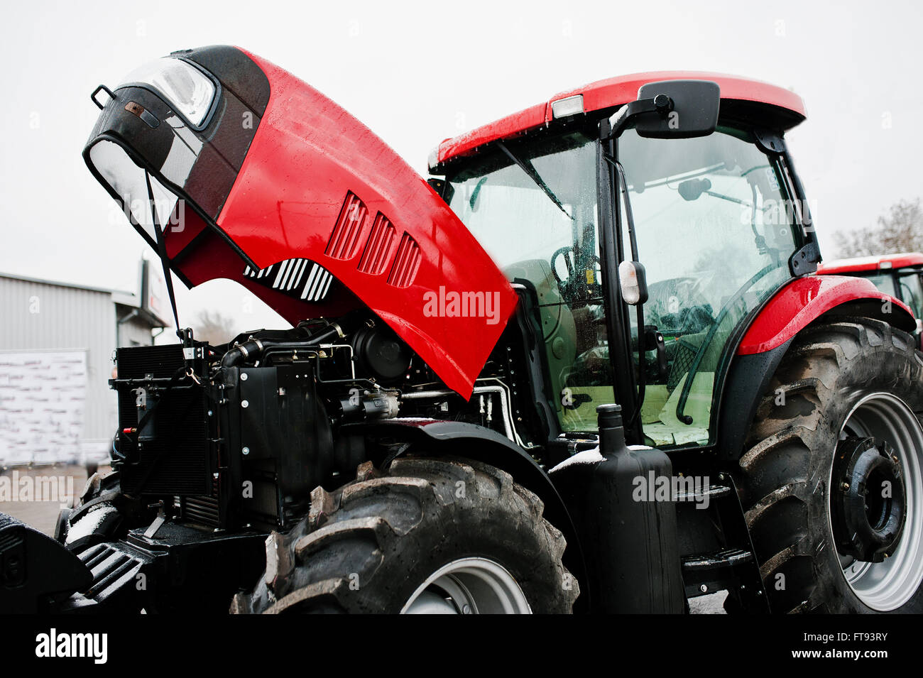 Close up in front of the new red tractor with open motor Stock Photo ...