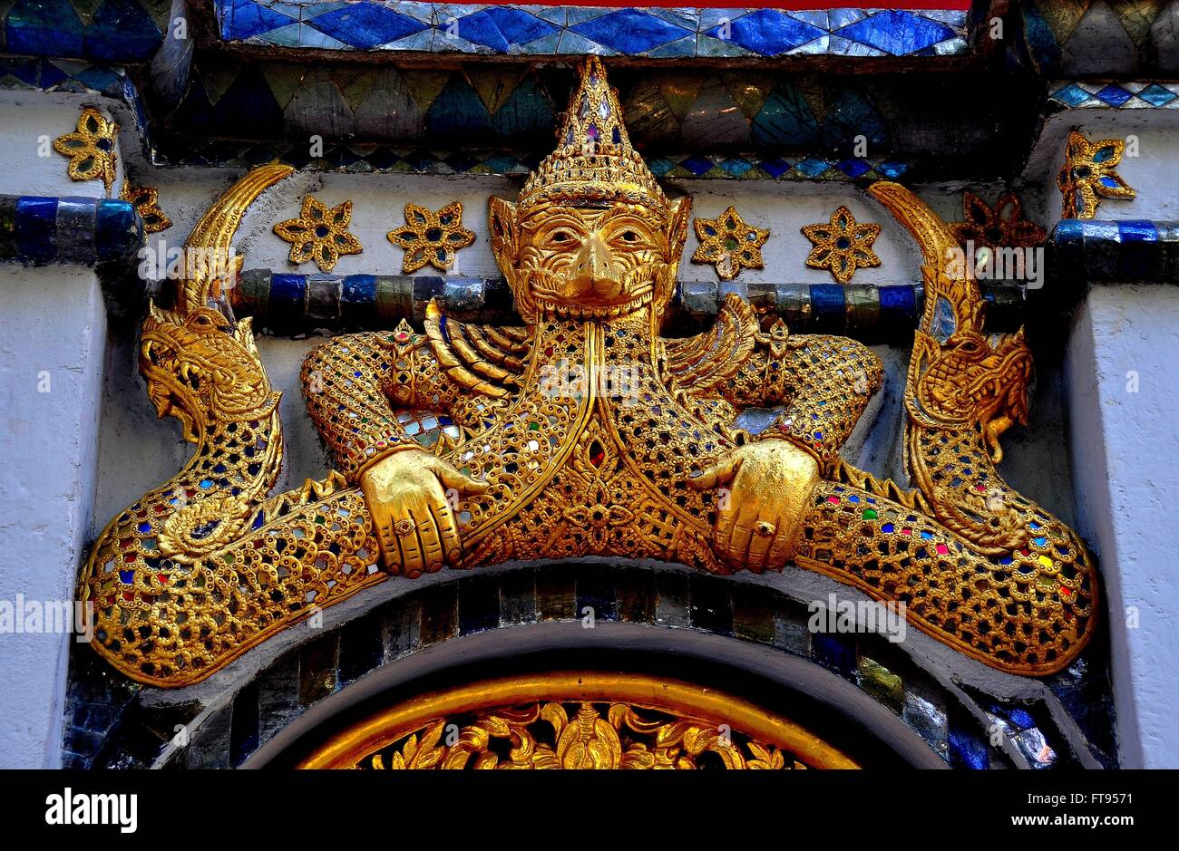 Chiang Mai, Thailand:  Gilded figure of a half-man, half-beast flanked by dragons adorn a doorway at Wat Mulan * Stock Photo