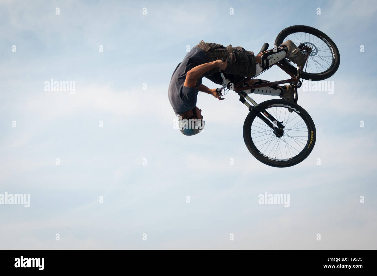 Biker with BMX bike jumping into the air performing stunt dirt jumping