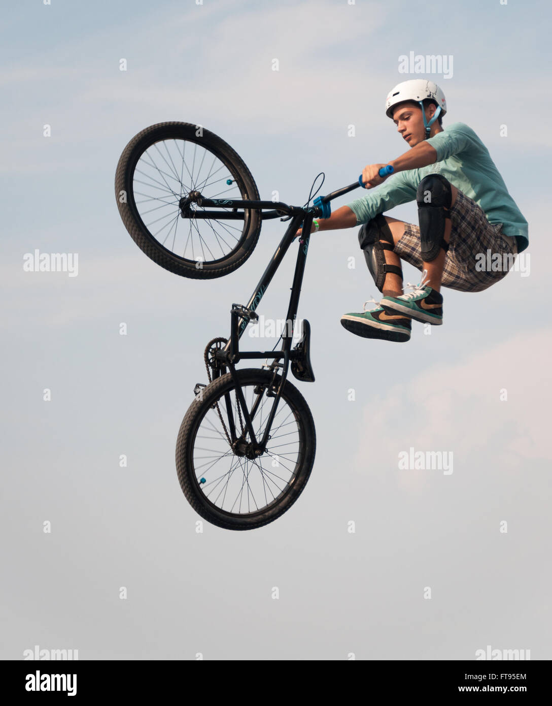 BMX biker jumping mid-air performing dirt jumping Stock Photo
